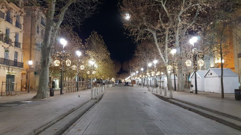 La grande allée du cours Mirabeau la nuit, bordée de platanes, de lanternes lumineuses et de chalets fermés