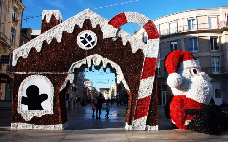 Arche en forme de maison en pain d’épices et de sucre d’orge, à côté d’un grand Père Noël, à l’entrée du marché de Noël d’Amiens