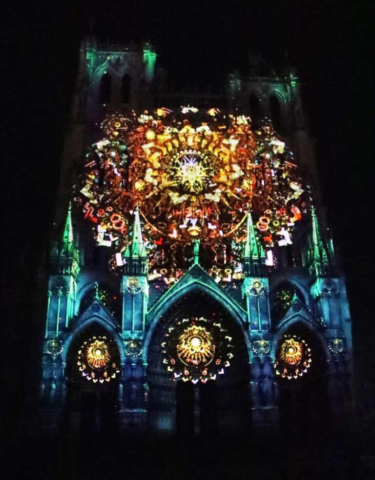 Projection lumineuse florale et colorée sur la façade de la cathédrale d’Amiens pendant le spectacle de Noël