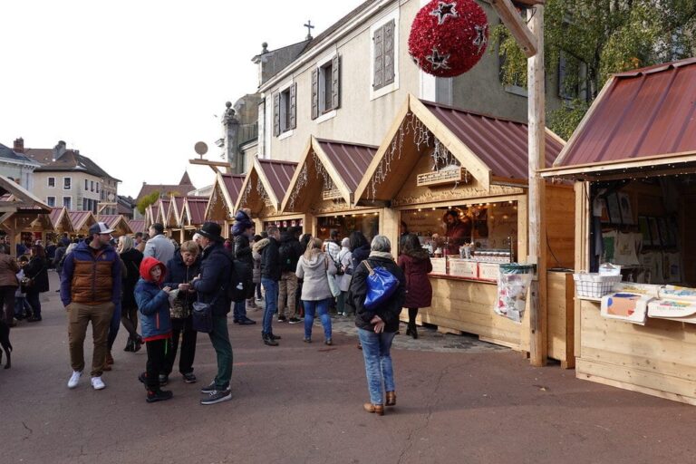 Une rangée de chalets en bois aux toits rouges du village de Noël des Alpes, dans la vieille ville d’Annecy