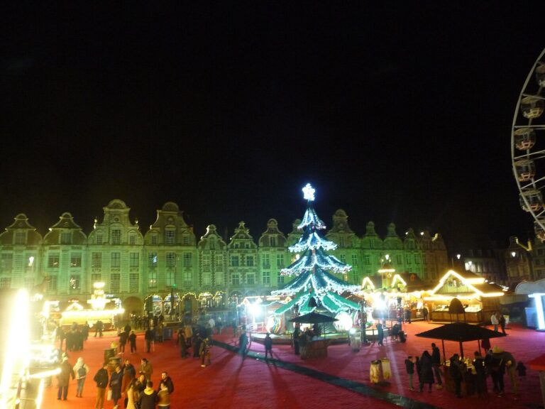 La Grand’Place d’Arras de nuit pendant le marché de Noël : chalets illuminés, sapin lumineux et façades éclairées en vert