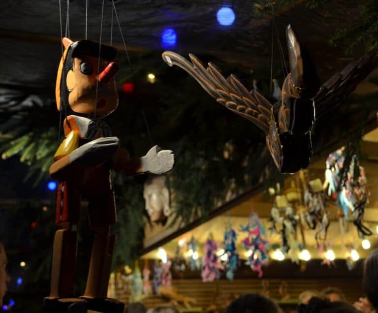 Marionnettes en bois suspendues dans un chalet du marché de Noël d’Arras