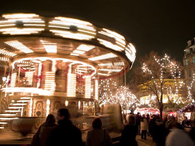 Manège en mouvement et arbres illuminés sur le marché de Noël des allées de Tourny, de nuit