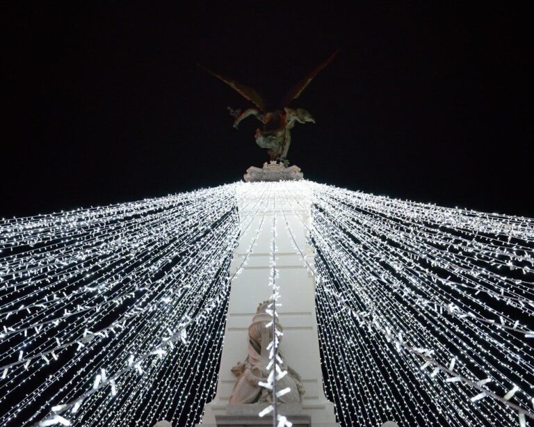 Des rideaux de guirlandes blanches rayonnant depuis la colonne de la place de la République, illuminations de Noël de Dijon