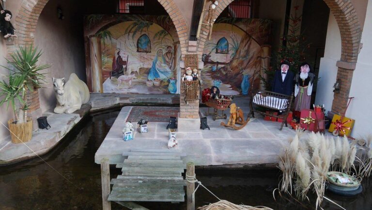 Une crèche de Noël installée sous des arcades, au ras de l’eau de la Weiss