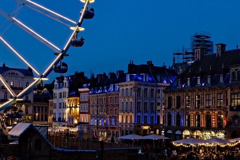 Façades flamandes illuminées de la Grand-Place à l’heure bleue, encadrées par une nacelle de la grande roue