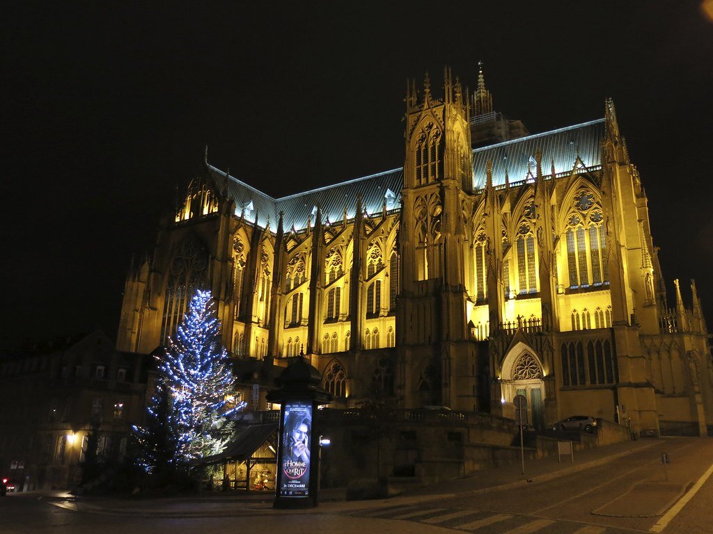 La cathédrale Saint-Étienne de Metz illuminée de nuit, avec un sapin aux lumières bleues à son pied