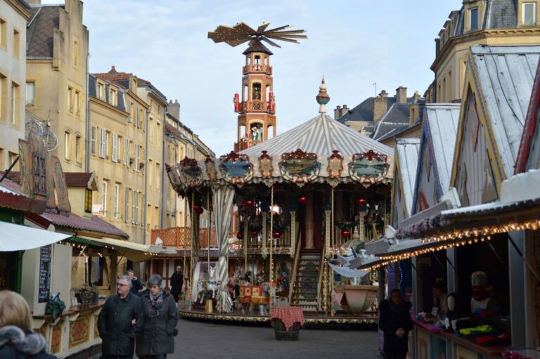 Pyramide de Noël en bois et manège ancien entre les chalets du marché de Noël de Metz