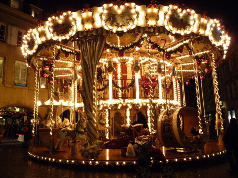 Manège ancien illuminé et décoré de guirlandes de Noël dans une rue de Metz, de nuit