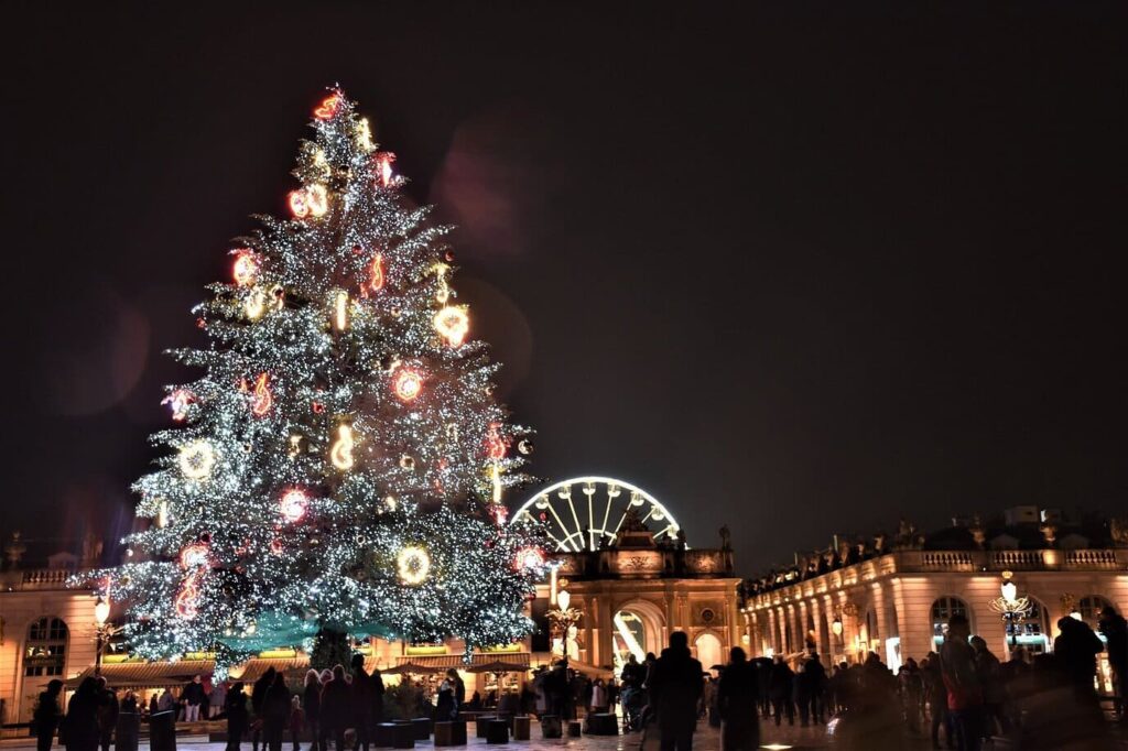 Le grand sapin illuminé de la place Stanislas, avec la grande roue et l’arc Héré en arrière-plan, un soir de fête