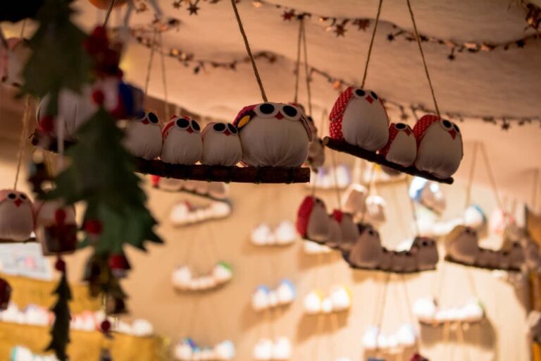 Décorations de Noël en forme de chouettes suspendues sous l’auvent d’un chalet du marché