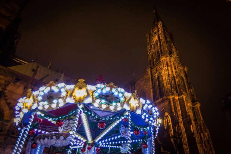 Un manège illuminé au pied de la cathédrale de Strasbourg, la nuit