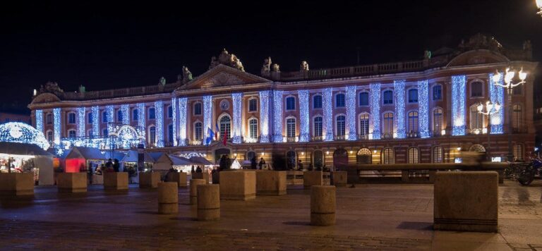 Vue panoramique de la façade du Capitole illuminée de bleu et de blanc, de nuit