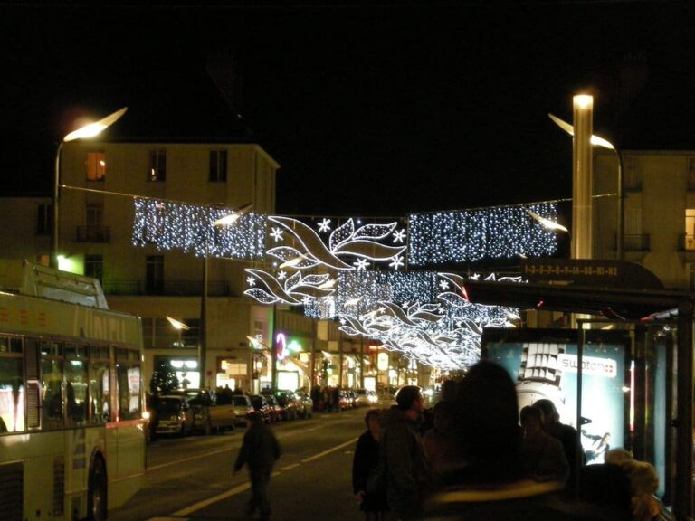 Guirlandes lumineuses en forme d’ailes et de rideaux de lumière au-dessus de la rue Nationale, de nuit
