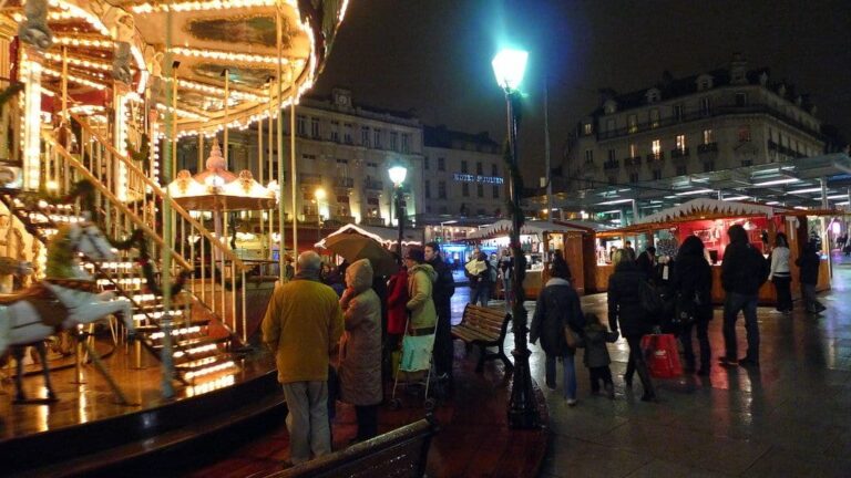 Carrousel illuminé et chalets du marché de Noël de la place du Ralliement, sous les lampadaires, de nuit