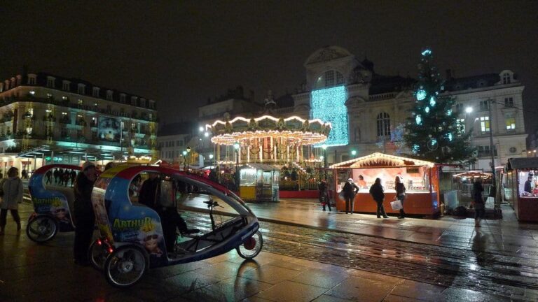 Le Grand Théâtre illuminé, le carrousel et le grand sapin de la place du Ralliement, vus depuis les rails du tramway