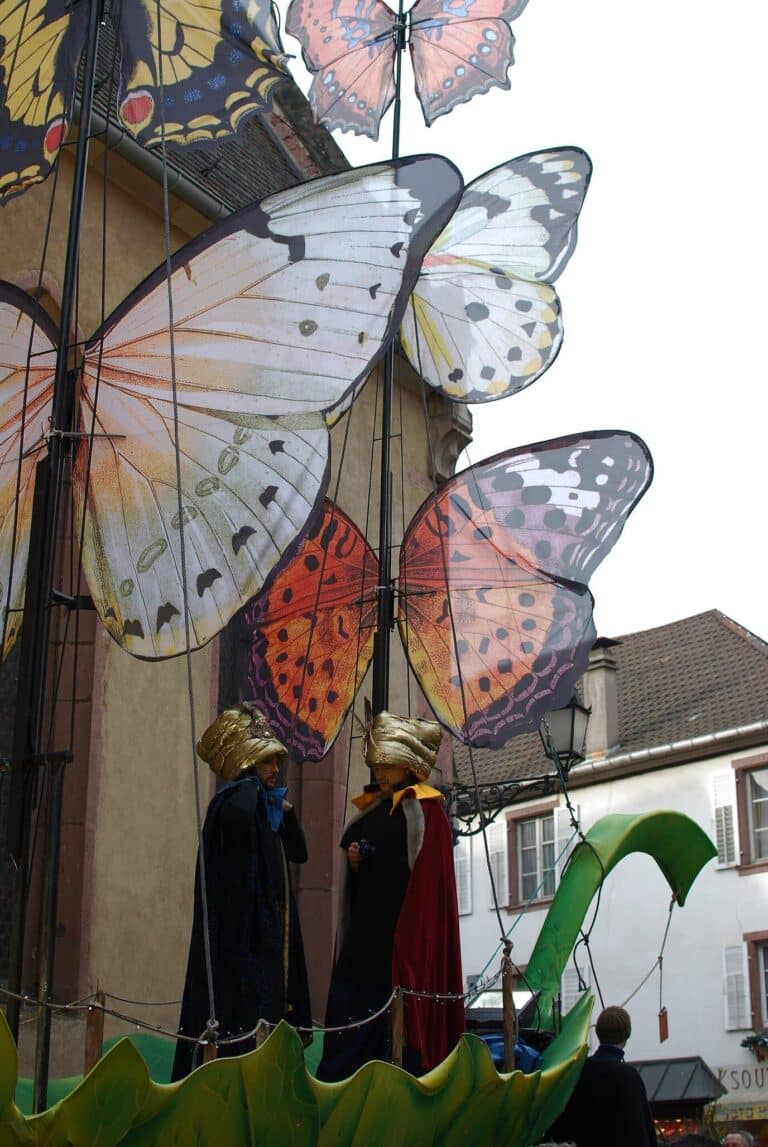 Grands papillons décoratifs et personnages costumés installés pour la fête de Noël médiévale