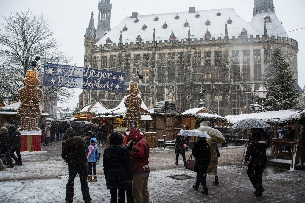 Le marché du Markt sous la neige, avec ses deux grands Printenmänner, la banderole du marché et l’hôtel de ville d’Aix-la-Chapelle au fond