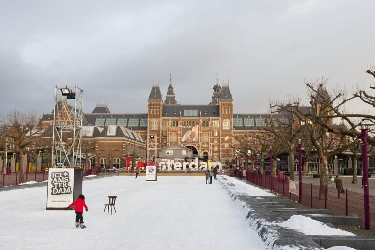 Le Museumplein enneigé avec sa patinoire d’hiver, devant la façade sud du Rijksmuseum d’Amsterdam