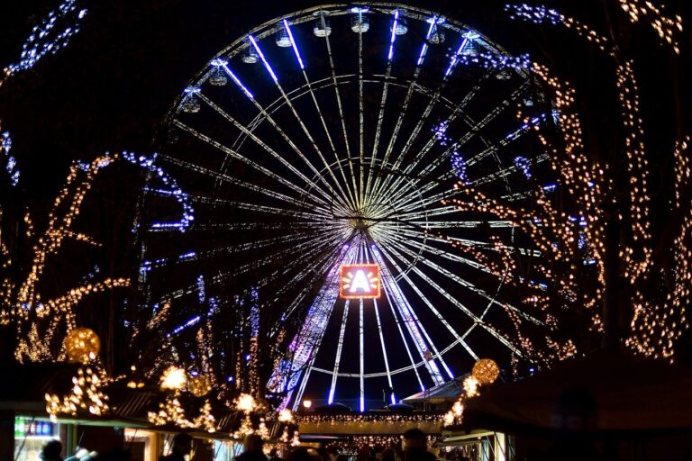 La grande roue illuminée du Steenplein, encadrée d’arbres couverts de guirlandes lumineuses, la nuit