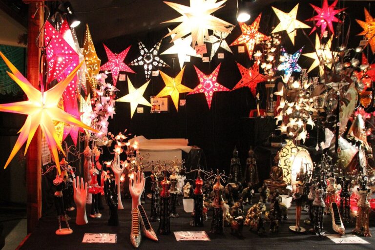 Étoiles lumineuses de toutes les couleurs suspendues dans un chalet du marché de Noël de Baden-Baden, au-dessus de figurines et de décorations
