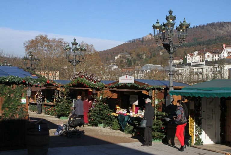 Chalets décorés du marché de Noël près du Kurhaus, avec réverbères anciens et collines boisées de Baden-Baden en arrière-plan, par temps clair