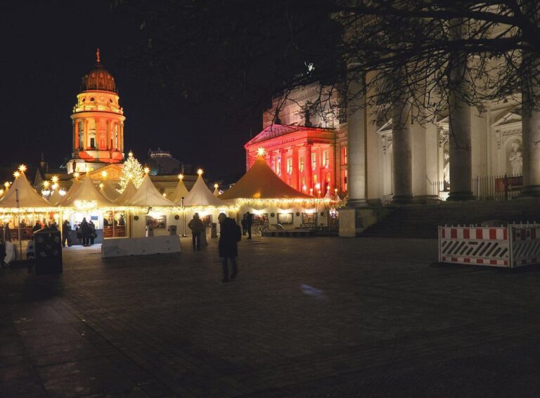 Les tentes blanches du marché de Noël alignées sur le Gendarmenmarkt, au pied du dôme illuminé et du Konzerthaus, le soir