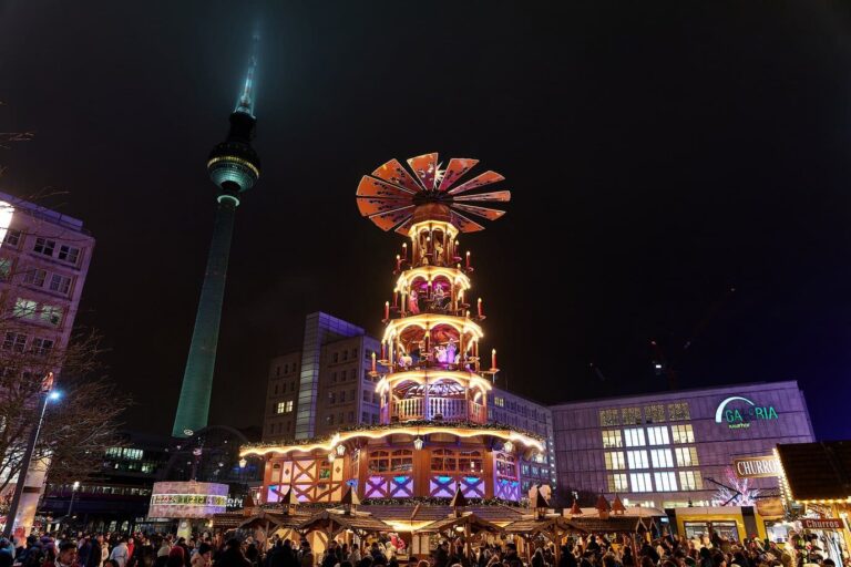 La grande pyramide de Noël illuminée de l’Alexanderplatz, avec la tour de télévision de Berlin à gauche, la nuit