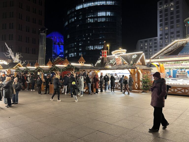 Les chalets du marché de Noël de Potsdamer Platz, au pied des tours de verre éclairées, le soir
