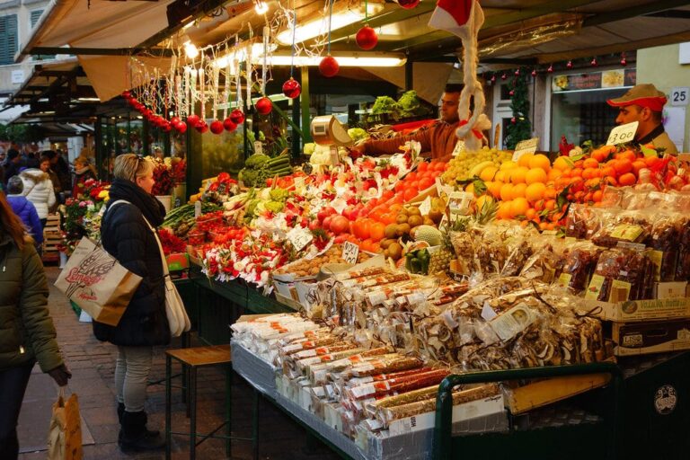 Étal de fruits et de pâtisseries de Noël décoré de boules rouges au marché de la piazza delle Erbe, à Bolzano