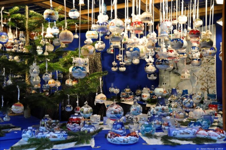 Boules de verre peintes de paysages enneigés, suspendues par dizaines dans un chalet du marché