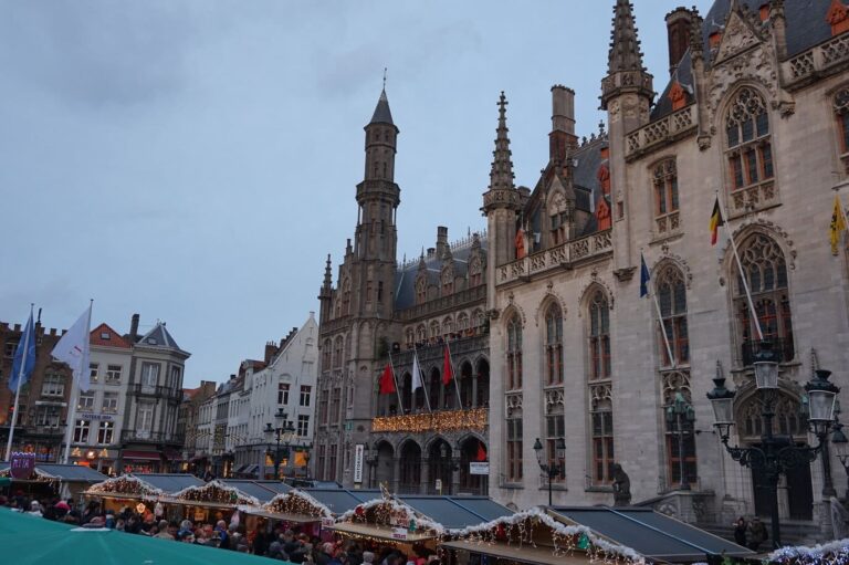 Les toits des chalets du marché au pied du Provinciaal Hof et de ses tourelles gothiques, en fin de journée