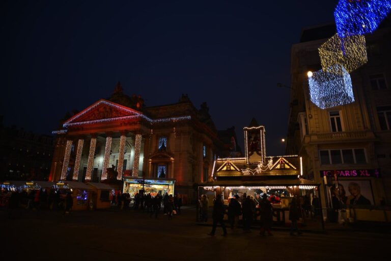 Le palais de la Bourse habillé de lumières et les chalets du marché devant sa façade, la nuit