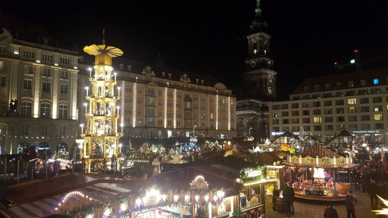 L’Altmarkt de nuit, avec la pyramide de Noël géante, les chalets éclairés et un manège
