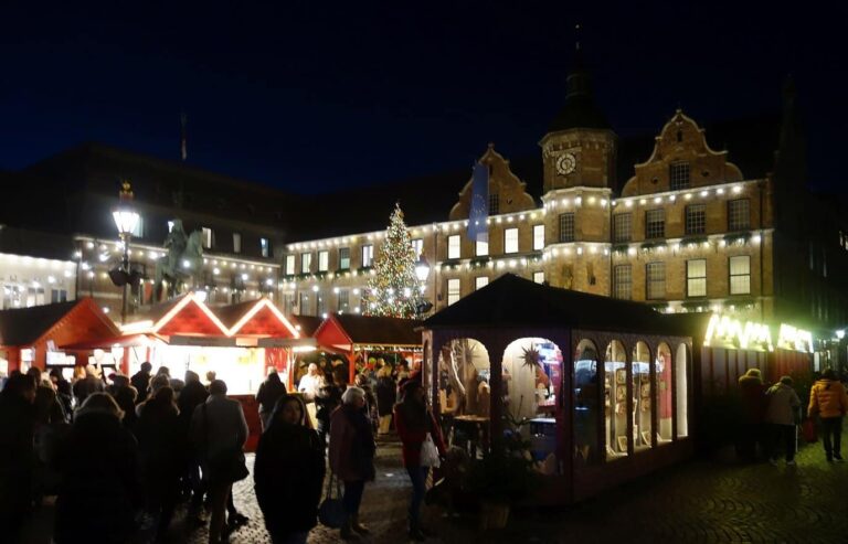 Les chalets illuminés du marché de Noël devant l’hôtel de ville Renaissance de Düsseldorf, la nuit
