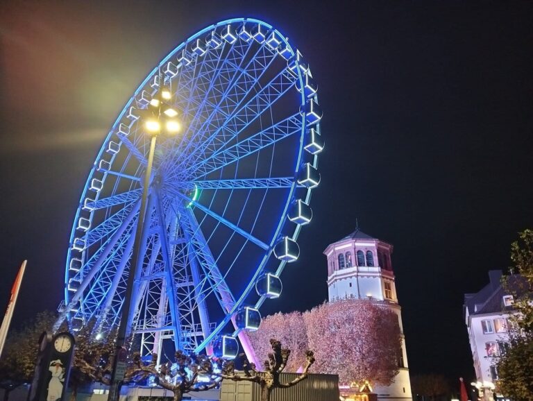 La grande roue illuminée en bleu du Burgplatz à côté de la tour du château (Schlossturm), la nuit