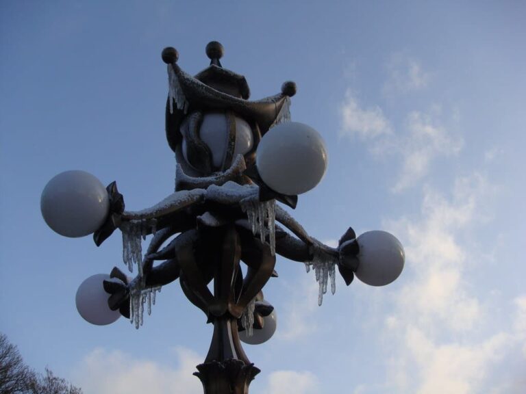 Lampadaire ouvragé du parc Efteling couvert de givre et de petits glaçons, sur un ciel bleu d’hiver