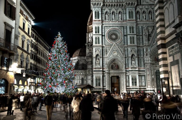 Grand sapin illuminé sur la piazza del Duomo, à côté de la façade de marbre de la cathédrale Santa Maria del Fiore, la nuit