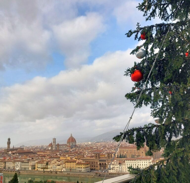 Branches du sapin de Noël décoré de boules rouges au piazzale Michelangelo, avec la vue sur Florence et la coupole du Duomo en contrebas
