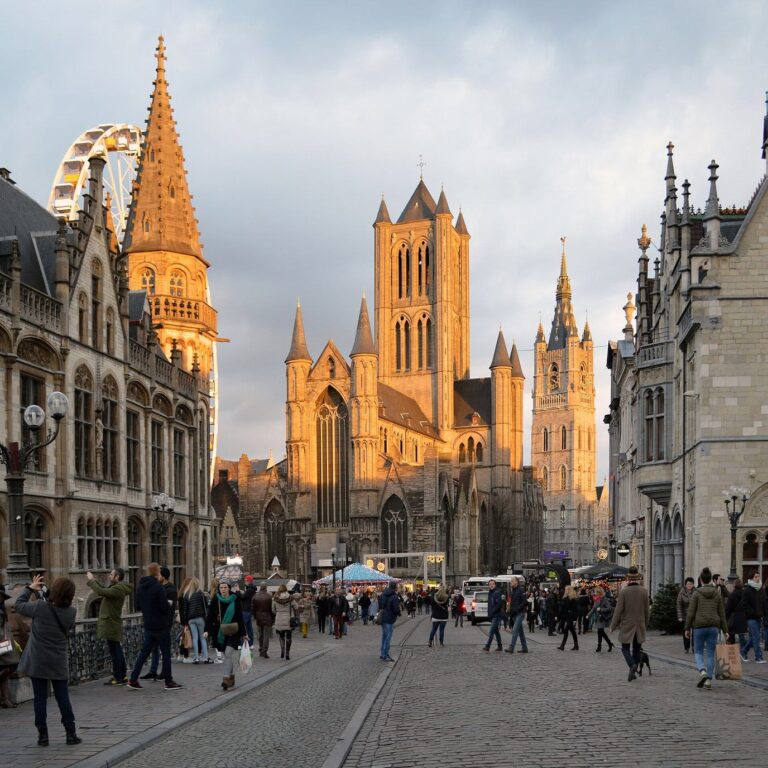 Le Korenmarkt et l’église Saint-Nicolas dorés par le soleil couchant, vus depuis le pont Saint-Michel, la grande roue à gauche