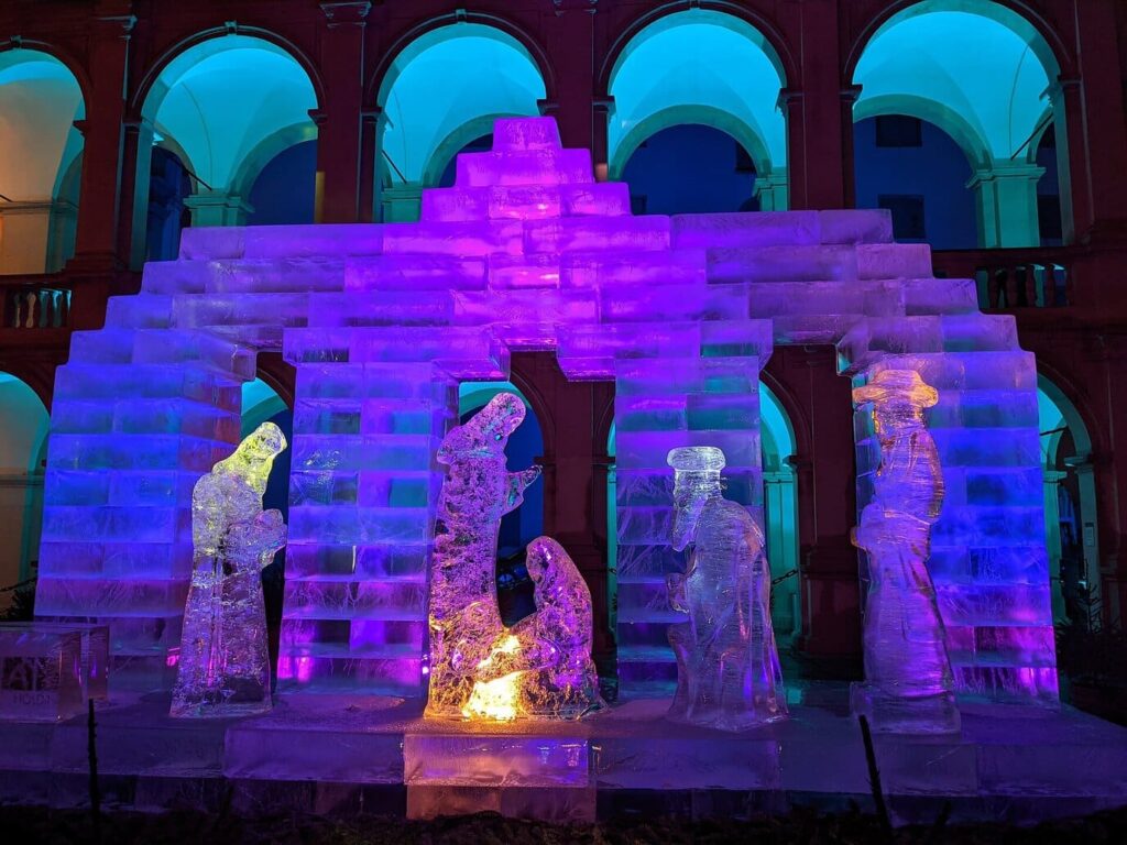 La crèche de glace du Landhaushof de Graz, éclairée en violet, avec ses personnages sculptés dans la glace sous les arcades Renaissance, à la nuit tombée