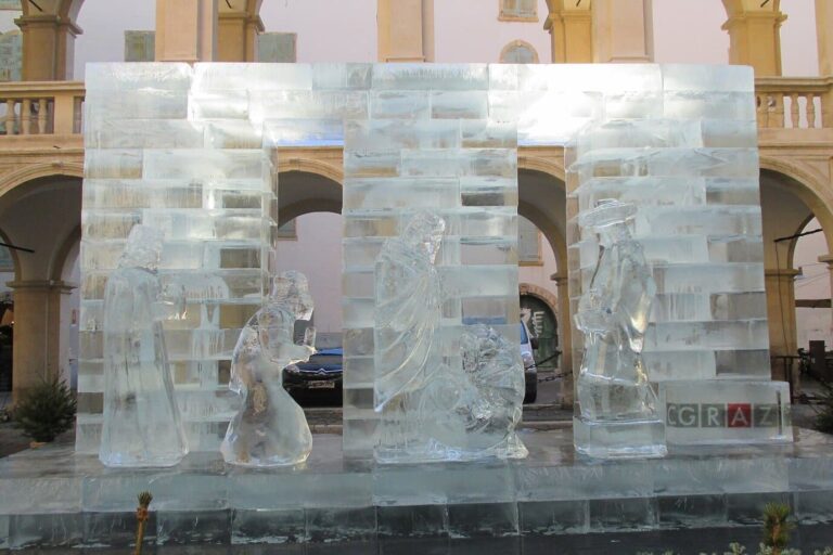 Crèche sculptée dans des blocs de glace devant les arcades du Landhaushof de Graz, avec Marie, Joseph et l’Enfant Jésus