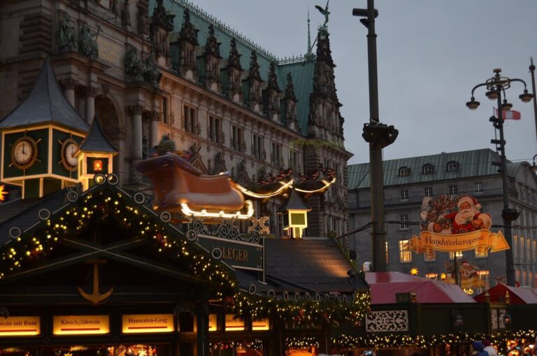 Les toits décorés des chalets du Rathausmarkt et un traîneau du père Noël devant la façade de l’hôtel de ville de Hambourg