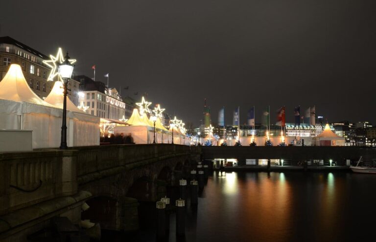 Les tentes blanches du marché du Jungfernstieg et leurs étoiles lumineuses au bord de la Binnenalster, la nuit