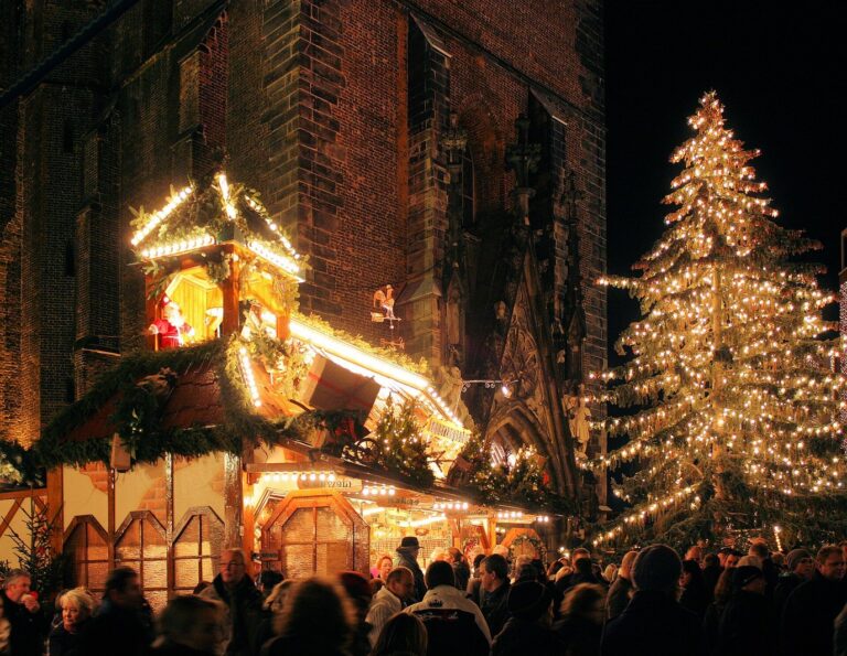 Un chalet décoré de guirlandes et le grand sapin illuminé du marché de Noël au pied de la Marktkirche, la nuit