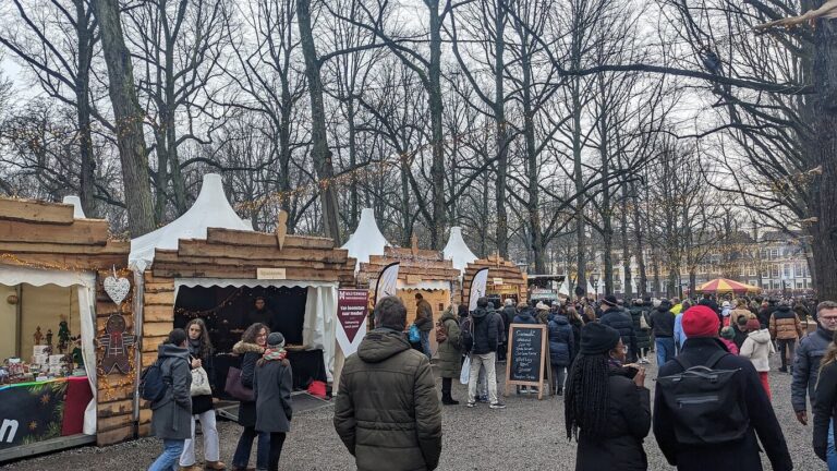 Allée de chalets en bois et de tentes pointues sous les grands arbres du Lange Voorhout, pendant la Royal Christmas Fair