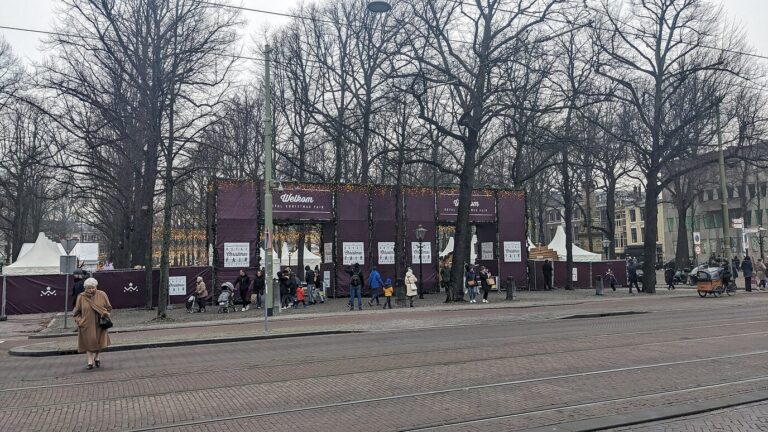 Vue d’ensemble du Lange Voorhout en décembre, avec la palissade et l’entrée de la Royal Christmas Fair sous les arbres