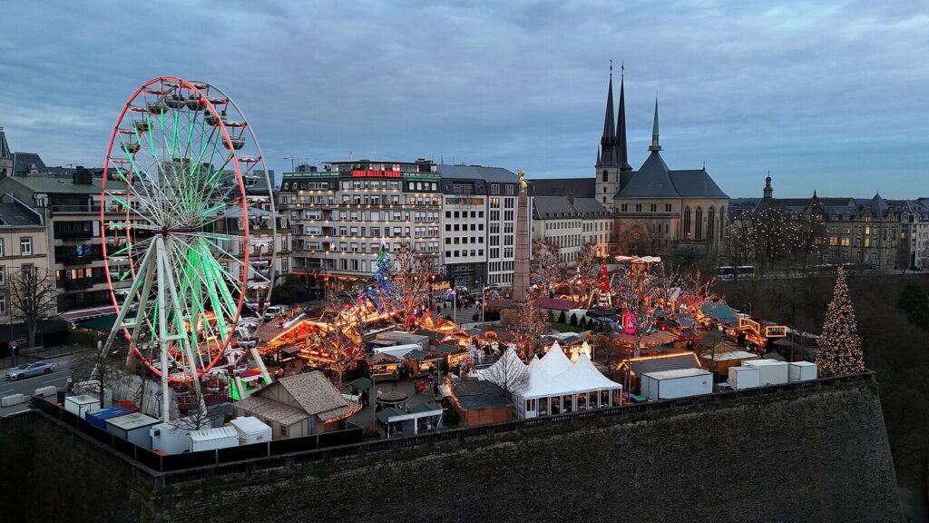 Le Wantermaart de la place de la Constitution vu d’en haut, avec sa grande roue illuminée et les tours de la cathédrale Notre-Dame de Luxembourg
