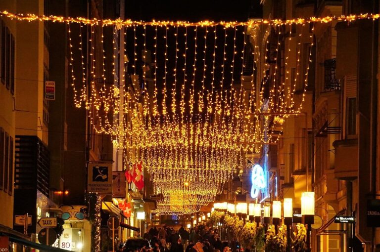 Rideaux de lumières dorées suspendus au-dessus de la rue Philippe-II, rue commerçante de Luxembourg, un soir de décembre