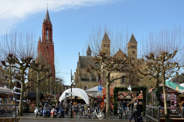 Le Vrijthof en décembre, avec la tour rouge de l’église Saint-Jean et la basilique Saint-Servais au-dessus des chalets du marché de Noël